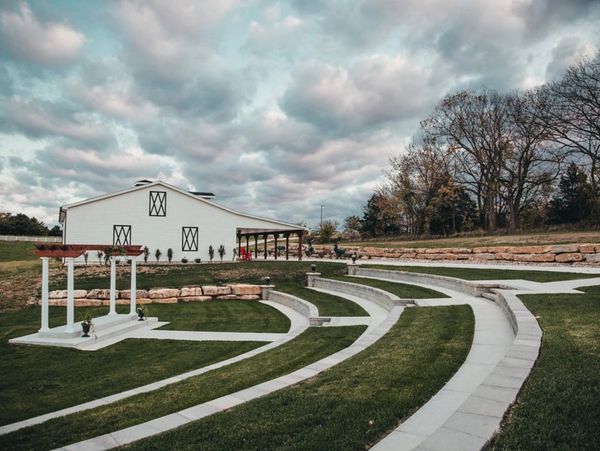 Outdoor amphitheater with white pavilion and cloudy sky.