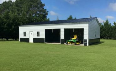 A white and black garage with two open bays and a lawnmower inside one bay.