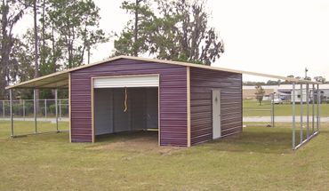 A purple metal carport with side extensions on a grassy lawn.