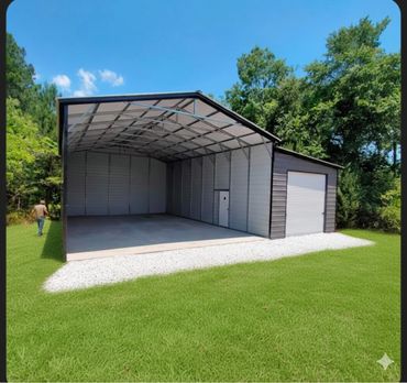 Large metal garage with open front and side door in a grassy area.