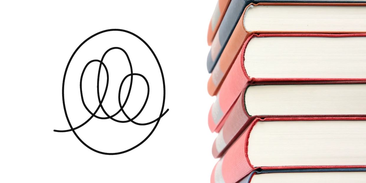 Stack of books beside a scribbled circular line on white background.