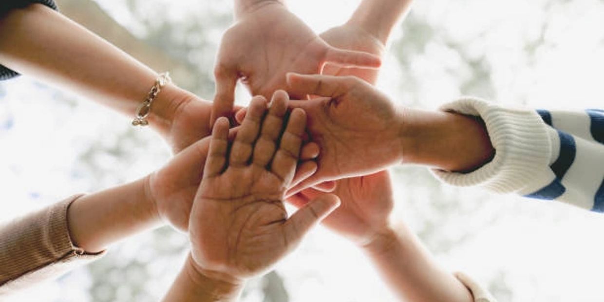 Multiple hands stacked together symbolizing unity and teamwork.