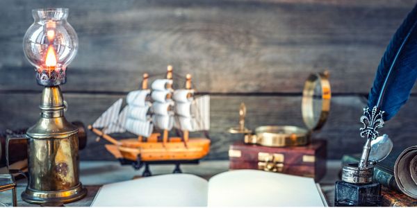 Antique maritime-themed study with model ship and quill pen.