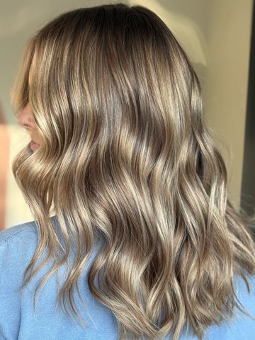 Shiny, wavy light brown hair with subtle blonde highlights.