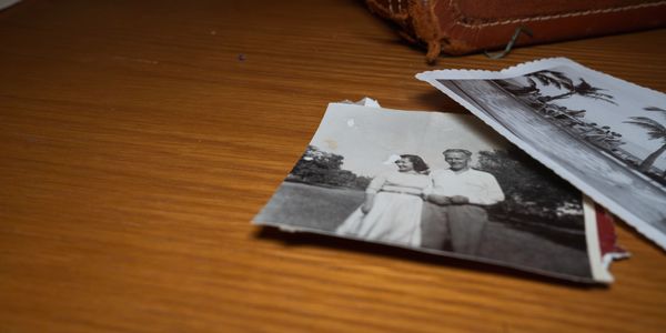 Old black-and-white photos on a wooden surface.