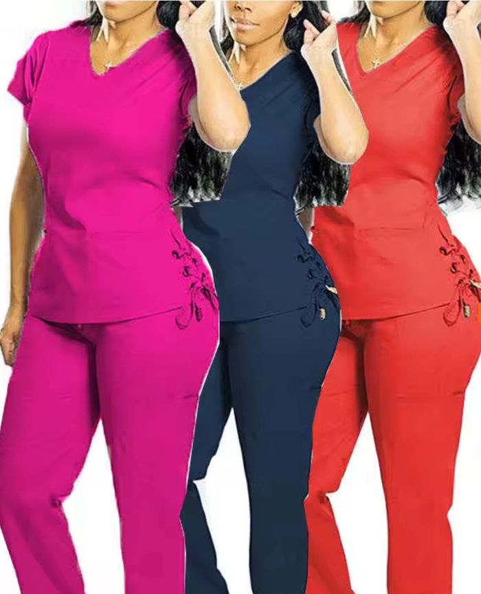 Women modeling colorful scrub sets in pink, navy, and red with side lace-up details.