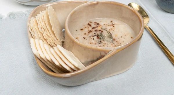 Dipping sauce and crackers in a ceramic bowl.