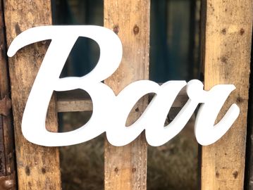 White decorative 'Bar' sign on wooden slats.