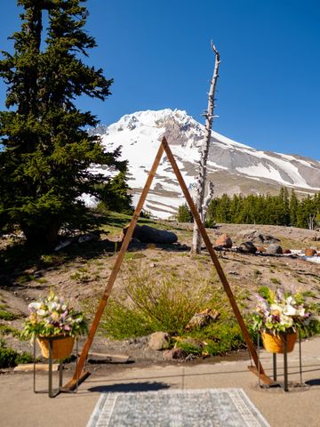 Large wooden triangle stands in front of a view of Mt. Hood. Photo by Beautiful Feeling Photography.