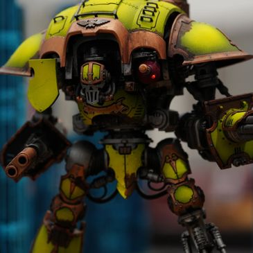 Detailed yellow and brown mech model with weathered paint standing on a textured base.