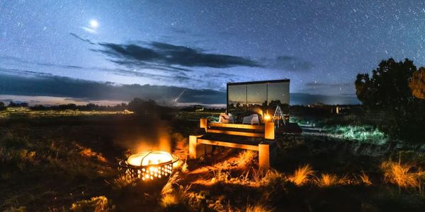 mirrored tiny home by fire light at dusk.