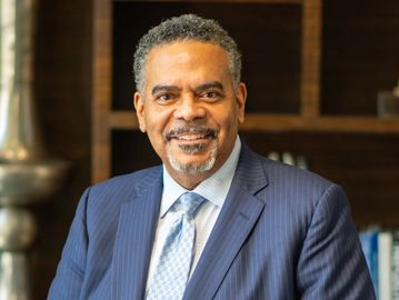 Professional man in a blue suit smiling.