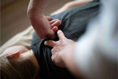 Hands performing a back massage.