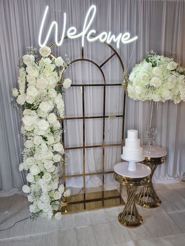 Includes
1 gold frame
1 neon sign
2 gold stands
(1) 6.5 floral garland
(1) L vase floral arrangement
