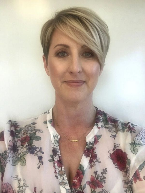 Woman with short blonde hair and floral blouse.