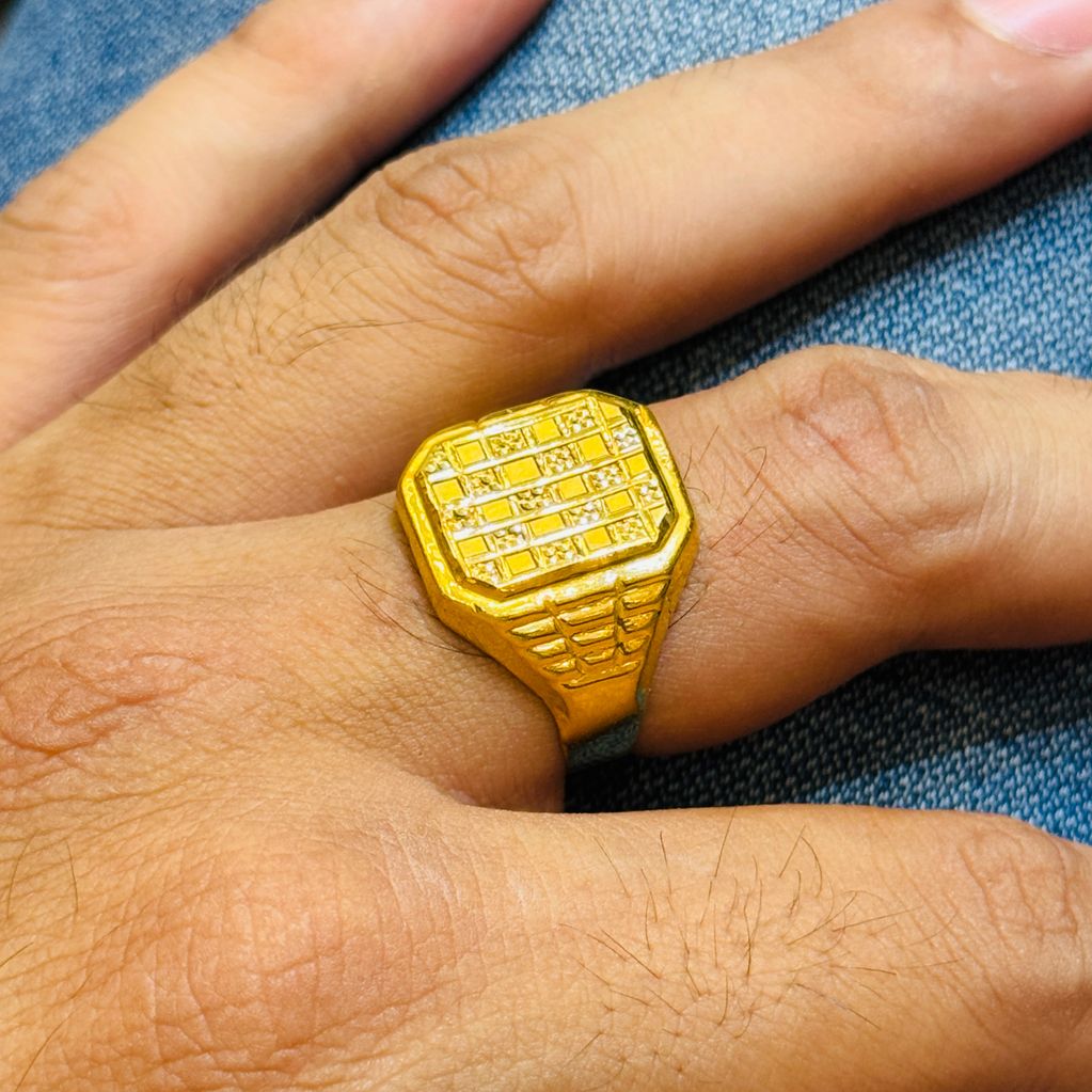 Gold ring with a rectangular diamond pattern worn on a finger.