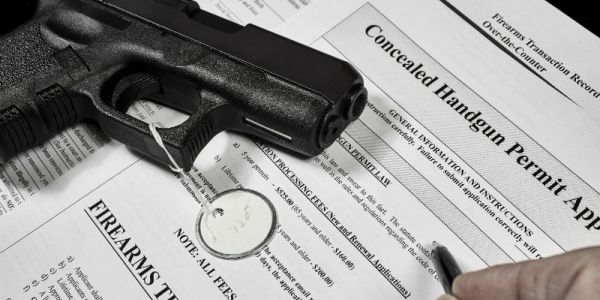 A handgun placed on a concealed handgun permit application form.