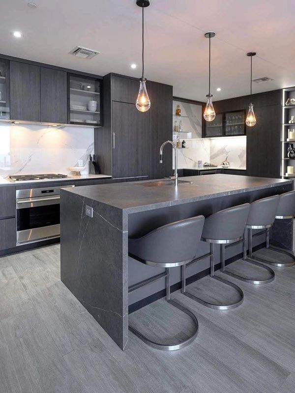 Modern kitchen with dark cabinetry and sleek island seating.