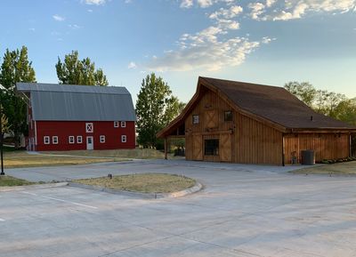 Two barns at entrance to Haven150, one brown and one traditional barn red with silver metal roof on 