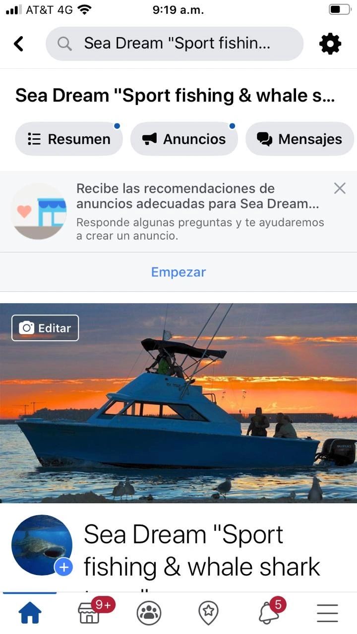 Fishing boat at sunset with people onboard and seagulls nearby.