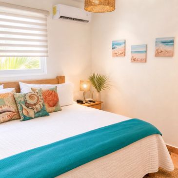 Cozy bedroom with beach-themed decor and teal accents.