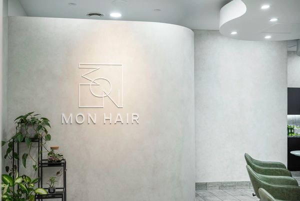 Physical Logo on stone wall inside Salon