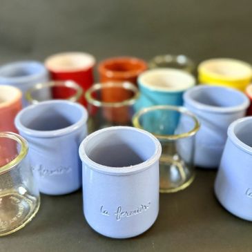 Colorful ceramic and glass containers arranged on a surface.