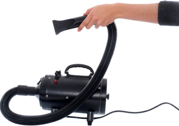 Hand holding a black vacuum cleaner hose.