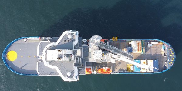 A large ship viewed from above on calm water.