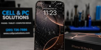 iPhone 16 Pro Max with cracked screen beside its box and repair tools.