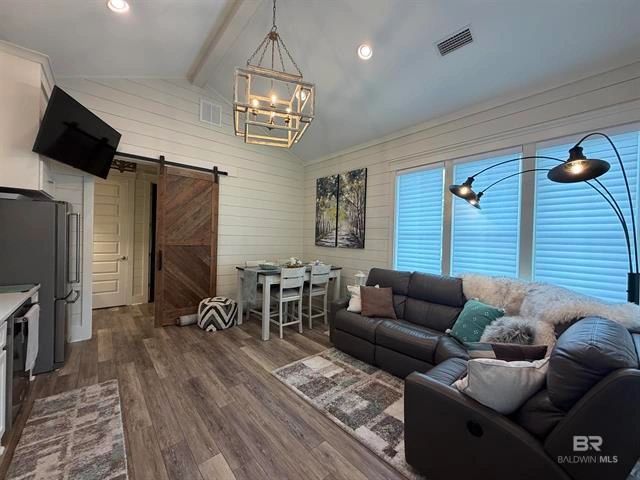 Cozy modern living room with leather sofas and rustic sliding barn door.