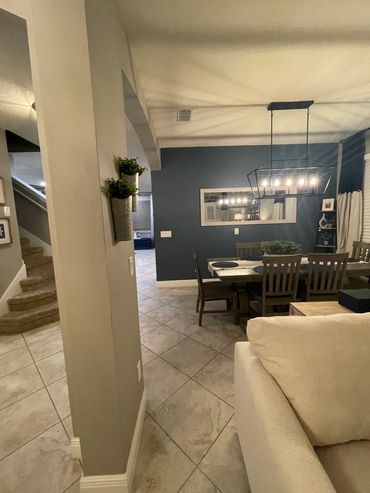 Cozy dining area with modern lighting and blue accent wall.