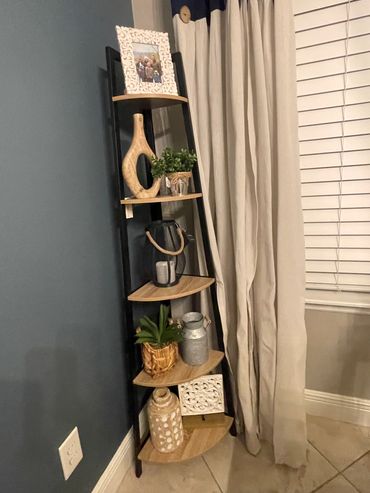 Corner shelf with decorative items and curtains.