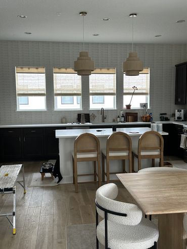 Modern kitchen with black cabinets and wooden stools.