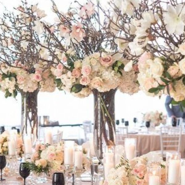 Grand centerpieces with tall branches, mixed with roses, hydrangeas and greens.