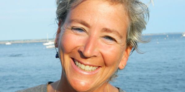 Smiling woman by the water on a sunny day