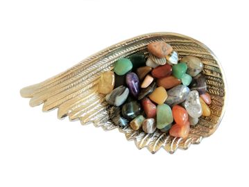 Different coloured tumblestones in a wing shaped bowl.