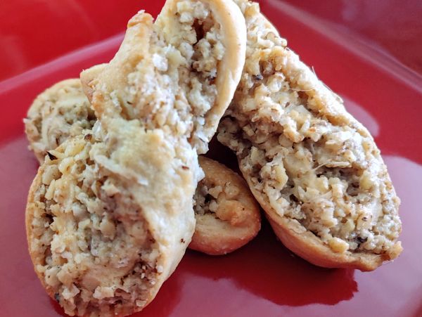 Close-up of baked pastries filled with a nut mixture on a red plate.