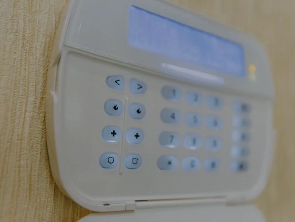 Wall-mounted security system keypad for arming and disarming an alarm system