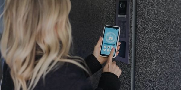 Individual using a mobile-enabled access control system for secure entry through a video intercom