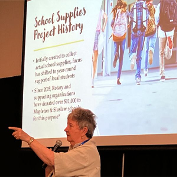 Woman presenting about school supplies project history.