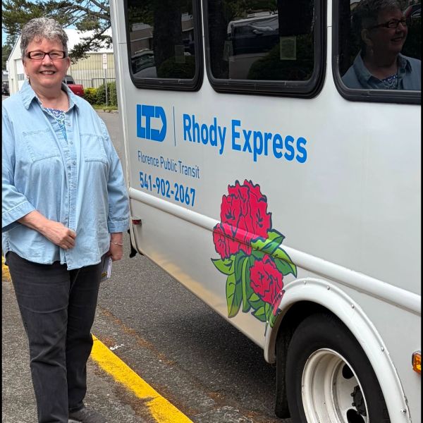 Woman standing by Rhody Express transit vehicle.