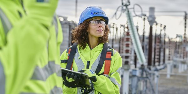Female engineer wearing a hard hat at an industrial site.