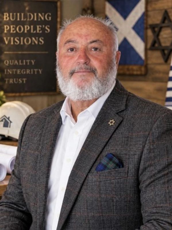 Bearded man in business attire with a Star of David pin.