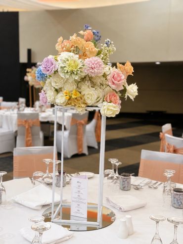 Elegant floral centerpiece on a white-covered banquet table at a formal event.