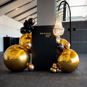 Black and gold balloons decorate the Blak Business Awards 2025 display.