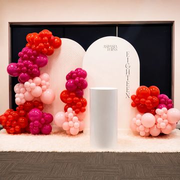 Colorful balloon arrangement for an eighteenth birthday celebration with a white pedestal.