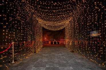 A hallway beautifully decorated with cascading warm fairy lights.