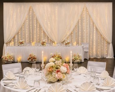 Elegant wedding reception setup with floral centerpieces and warm lighting.