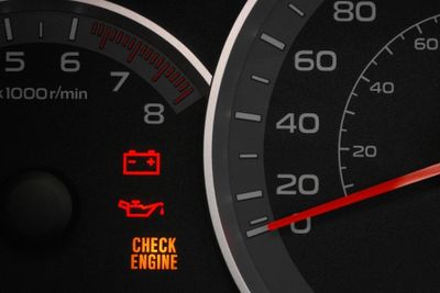 Car dashboard showing battery, oil, and check engine warning lights illuminated.